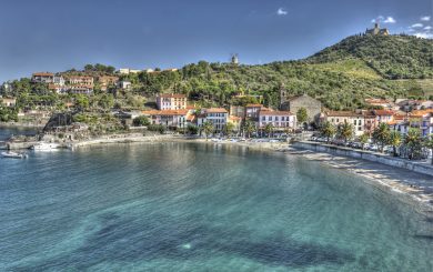 Das schöne Dorf und der Hafen von Collioure, Languedoc-Roussillon, Frankreich mit Blick auf das Mittelmeer, die alte Windmühle und die Ruine auf dem Hügel hinter dem Dorf